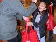 EAST VANCOUVER: Lilly Kovalenko high-fives Cali Lumbreras. More than 60 volunteers recently helped put together more than 1,000 packs to donate to those who are homeless or living in poverty at Share Vancouver.