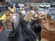 Marge Boulden, left, helps unload donated food at Chuck&#039;s Produce during the annual Walk &amp; Knock food drive.