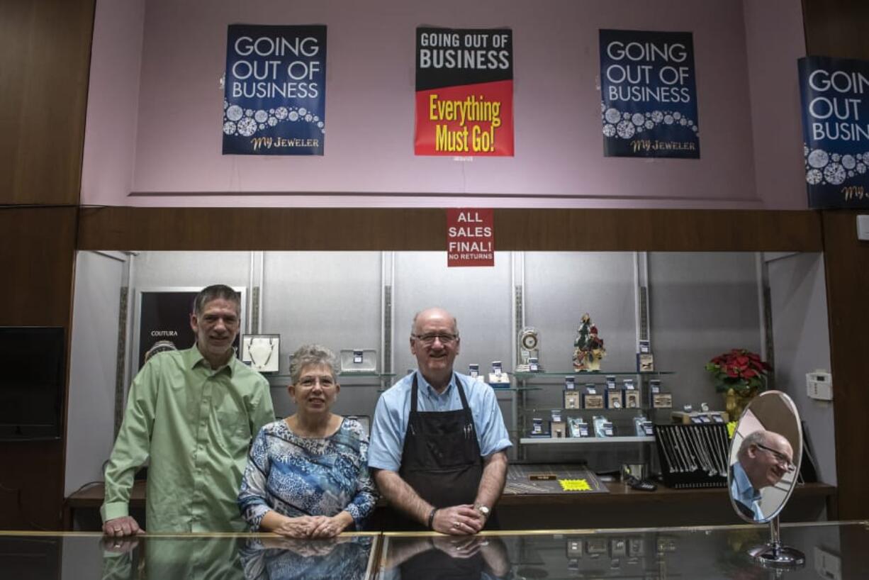 Chad Lanning, from left, Trudy Lanning and Joe Lanning pose behind the counter of My Jeweler in downtown Vancouver during their closing sale on Tuesday.