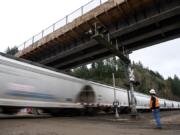 Mick Cannon, a superintendent for Ceccanti Inc. of Tacoma, waits for a fast-moving train before Monday&#039;s opening of a concrete bridge spanning the railroad tracks and Lake River at the Ridgefield National Wildlife Refuge.