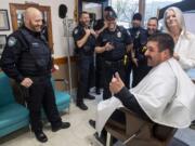 Camas police Officer Carlos Gonzalez, seated, reacts to his new mustache with other members of the Camas police force during a beard shaving fundraiser at Camas Barbershop on Wednesday. Cops in the department grew out their beards during No Shave November, and teamed with the barbershop to raise money on Wednesday for www.zerocancer.org, a nonprofit looking to end prostate cancer.