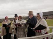 Re-enactors wearing 1840s clothing provide carols during Saturday&#039;s Christmas at Fort Vancouver.