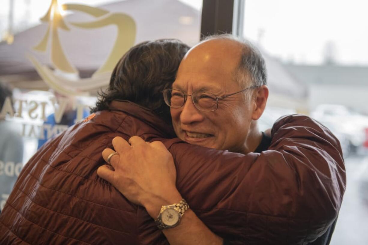 Cindy Hovind hugs Eugene Sakai during Sakai&#039;s coat drive in honor of his retirement from a 47-year dentistry career at Mount Vista Family Dental in Salmon Creek on Dec. 14. &quot;He&#039;s real giving and a happy person that is wonderful to have in the family,&quot; said Hovind. Many patients feel like friends to Sakai.