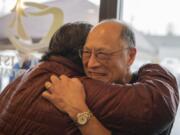 Cindy Hovind hugs Eugene Sakai during Sakai&#039;s coat drive in honor of his retirement from a 47-year dentistry career at Mount Vista Family Dental in Salmon Creek on Dec. 14. &quot;He&#039;s real giving and a happy person that is wonderful to have in the family,&quot; said Hovind. Many patients feel like friends to Sakai.