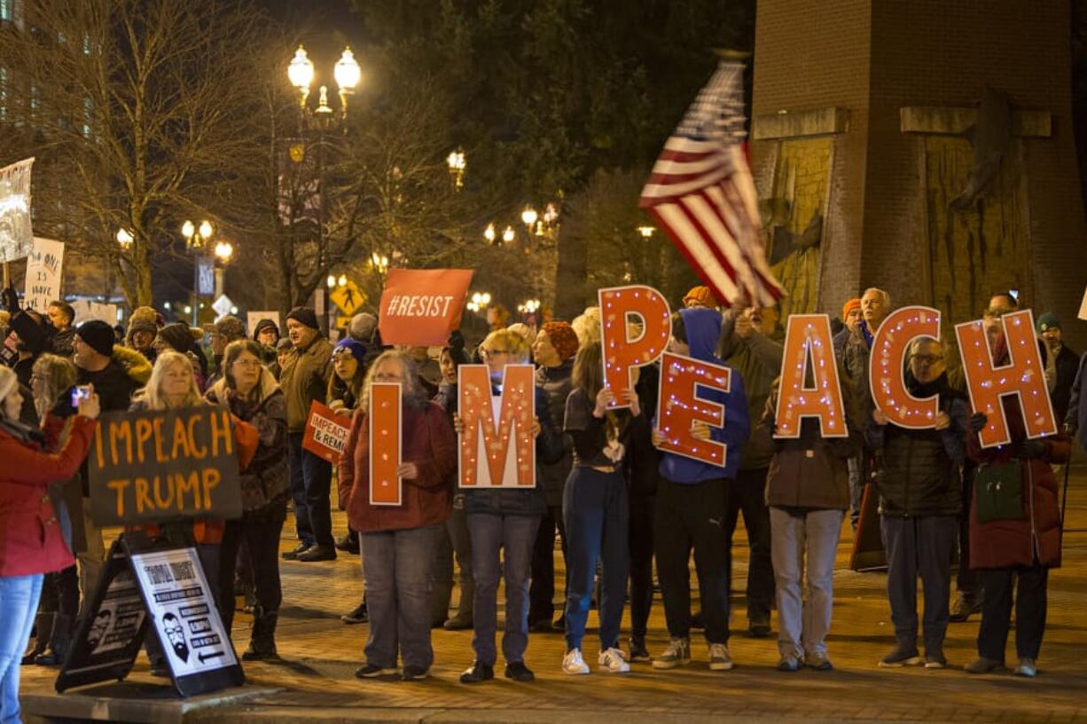 Demonstrators gather to support the impeachment of President Donald Trump during a rally at Esther Short Park on Tuesday evening. Participants kicked off the event with music and chants before hearing from speakers and waving signs along Sixth and Columbia streets.