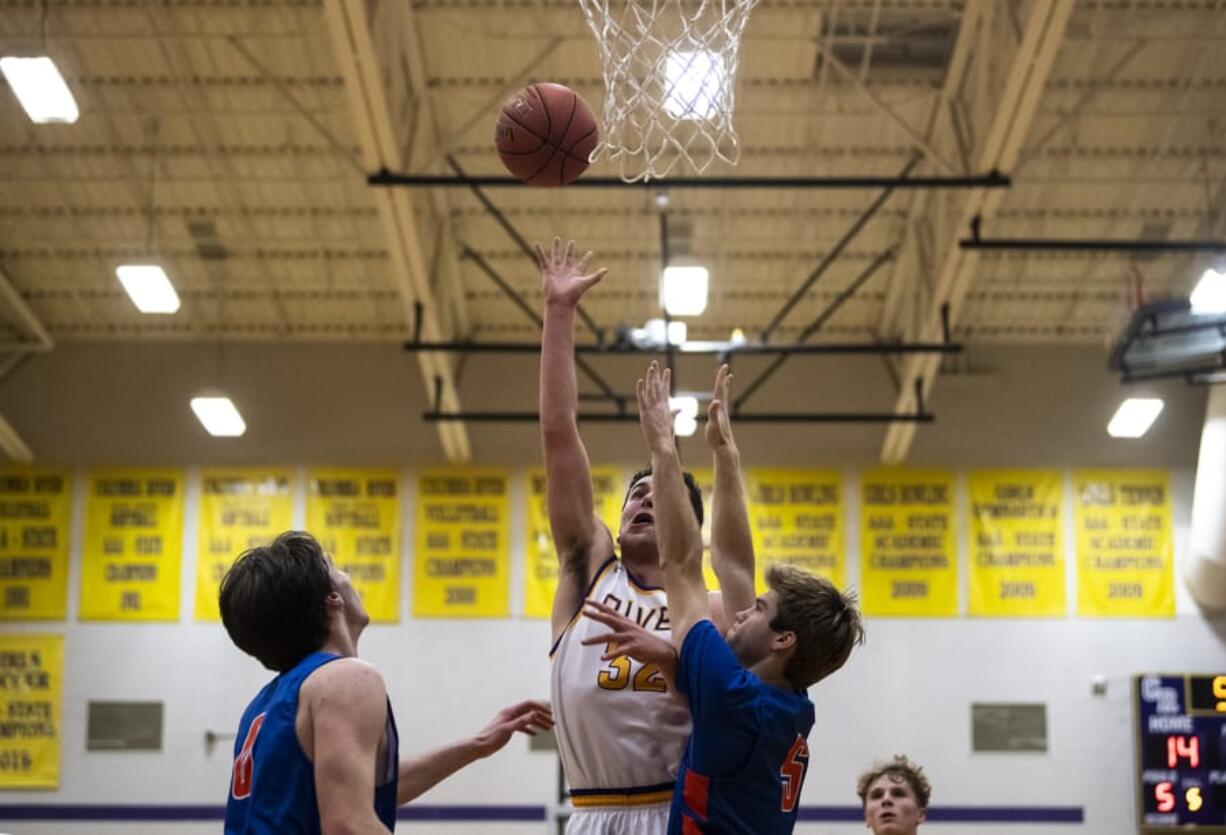 Columbia RiverCfUs Michael Foust completes a layup during a game against Ridgfield at Columbia River High School on Thursday night, Dec. 19, 2019.