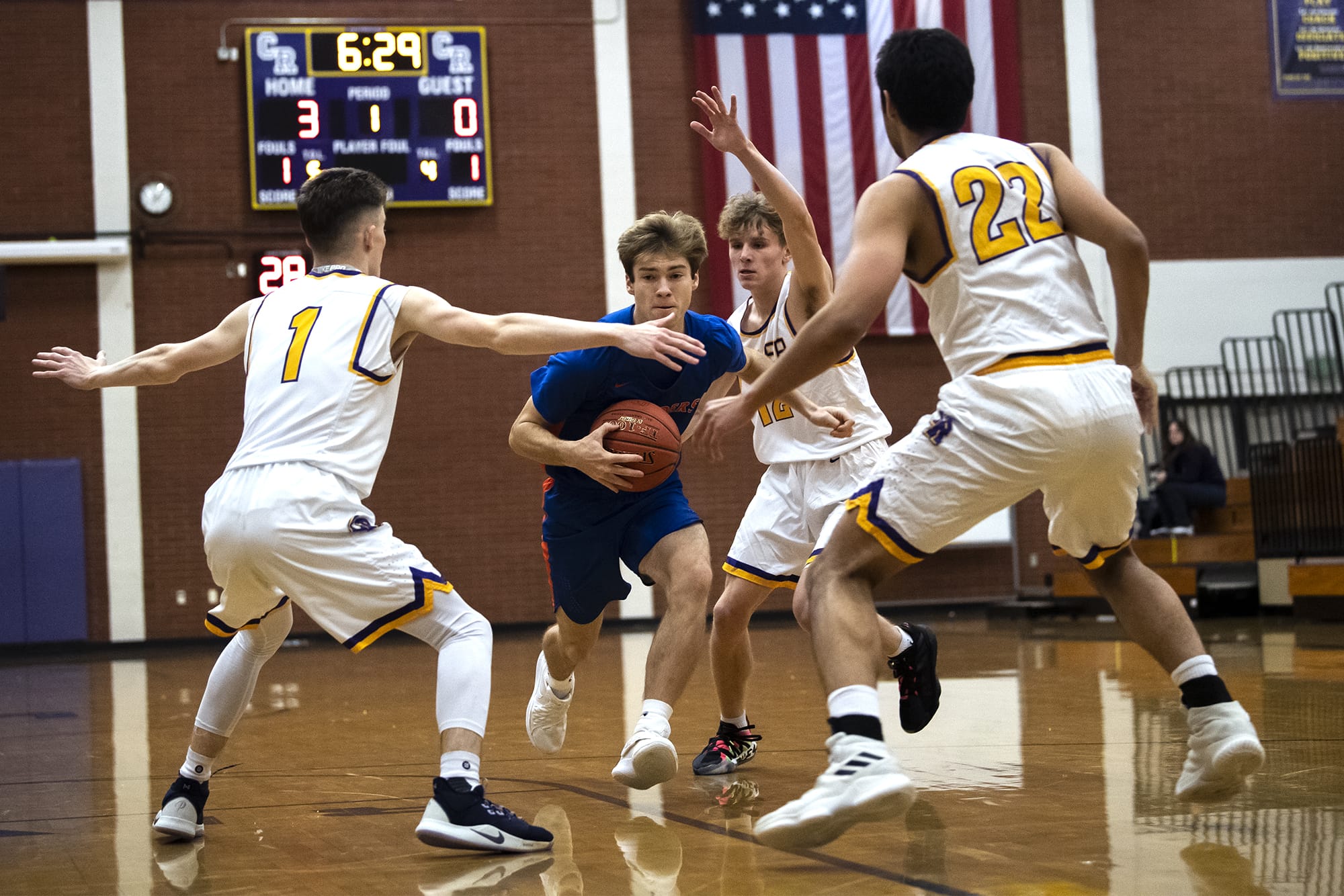 A drive by Ridgefield’s Josh Mansur is stopped by three Columbia River defenders during a game at Columbia River High School on Thursday night, Dec. 19, 2019.