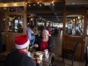 Peter Blanco, left, and his wife Susan, right, enjoy the annual free Christmas Day meal together at WareHouse &#039;23 in Vancouver. &quot;We&#039;re both disabled and preparing meals is sometimes difficult,&quot; Susan Blanco said. &quot;We&#039;re very grateful for the people who give up their Christmas Day.&quot; The meal is organized by WareHouse &#039;23 owner Mark Matthias, state Court of Appeals Judge Rich Melnick, and Chuck Chronis, who previously hosted it at his downtown Vancouver bar.