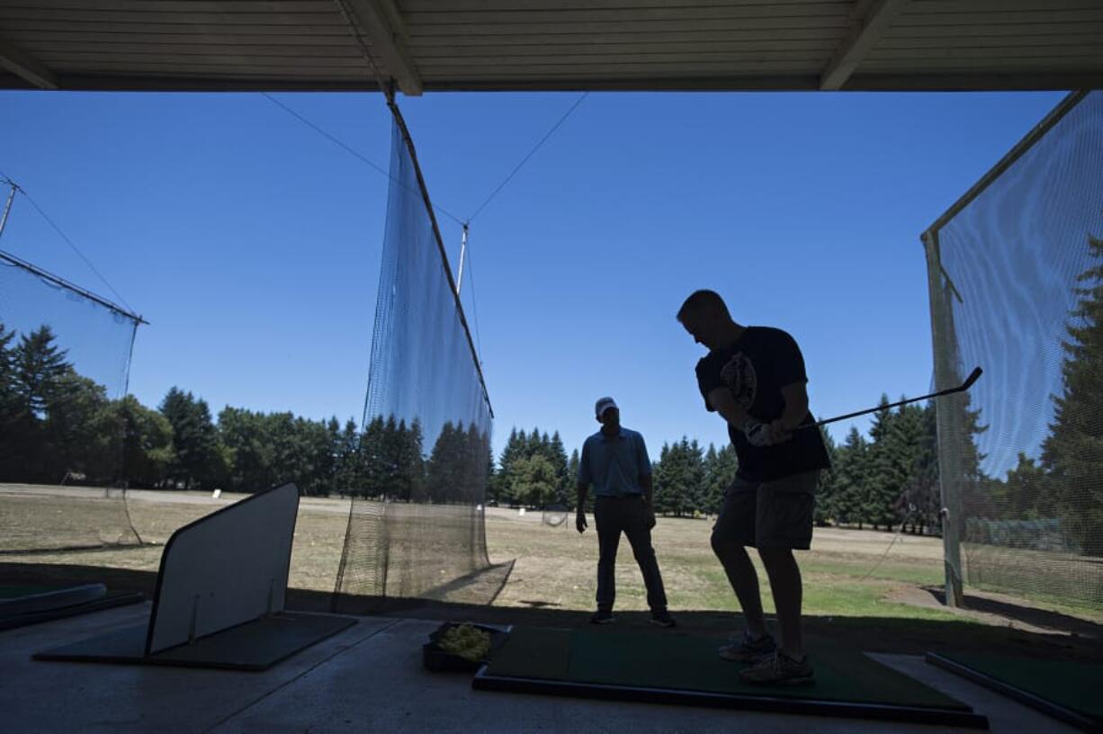 PGA teaching professional Jack Young, left, works with Vancouver resident Slade Langlois while giving him a few helpful tips at Vanco Golf Range on July 26. The city-owned range site is part of the redevelopment area for the Heights District project, and Vanco owner Chuck Milne had previously announced a plan to close the range at the end of 2020. A new lease agreement with the city will now allow the range to operate through 2024.