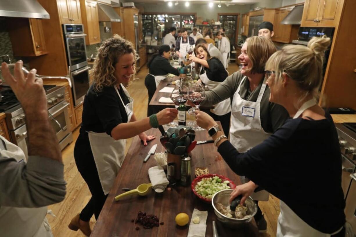 Guests Tarra Bathurst, clockwise from left, Brittany Georgiou and Sarah Schlichte clink their wine glasses during a dinner instruction course titled, &quot;Steakhouse DIY&quot; at the Chopping Block in Chicago. (John J.