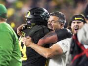 FILE - In this Dec. 6, 2018, file photo, Oregon coach Mario Cristobal, right, celebrates with offensive lineman Shane Lemieux (68) after Oregon defeated Utah 37-15 in an NCAA college football game for the Pac-12 Conference championship, in Santa Clara, Calif. Cristobal was named The Associated Press Pac-12 Coach of the Year Thursday, Dec. 12, 2019.