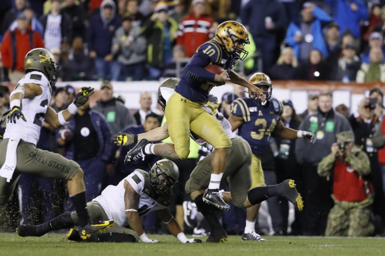 Navy&#039;s Malcolm Perry (10) leaps over Army&#039;s Donavan Lynch (11) during the second half of an NCAA college football game, Saturday, Dec. 14, 2019, in Philadelphia.