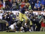 Navy&#039;s Malcolm Perry (10) leaps over Army&#039;s Donavan Lynch (11) during the second half of an NCAA college football game, Saturday, Dec. 14, 2019, in Philadelphia.