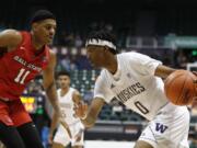 Washington forward Jayden McDaniels (0) goes toward the basket against Ball State guard Jarron Coleman (11) during the second half of an NCAA college basketball game, Sunday, Dec. 22, 2019, in Honolulu.