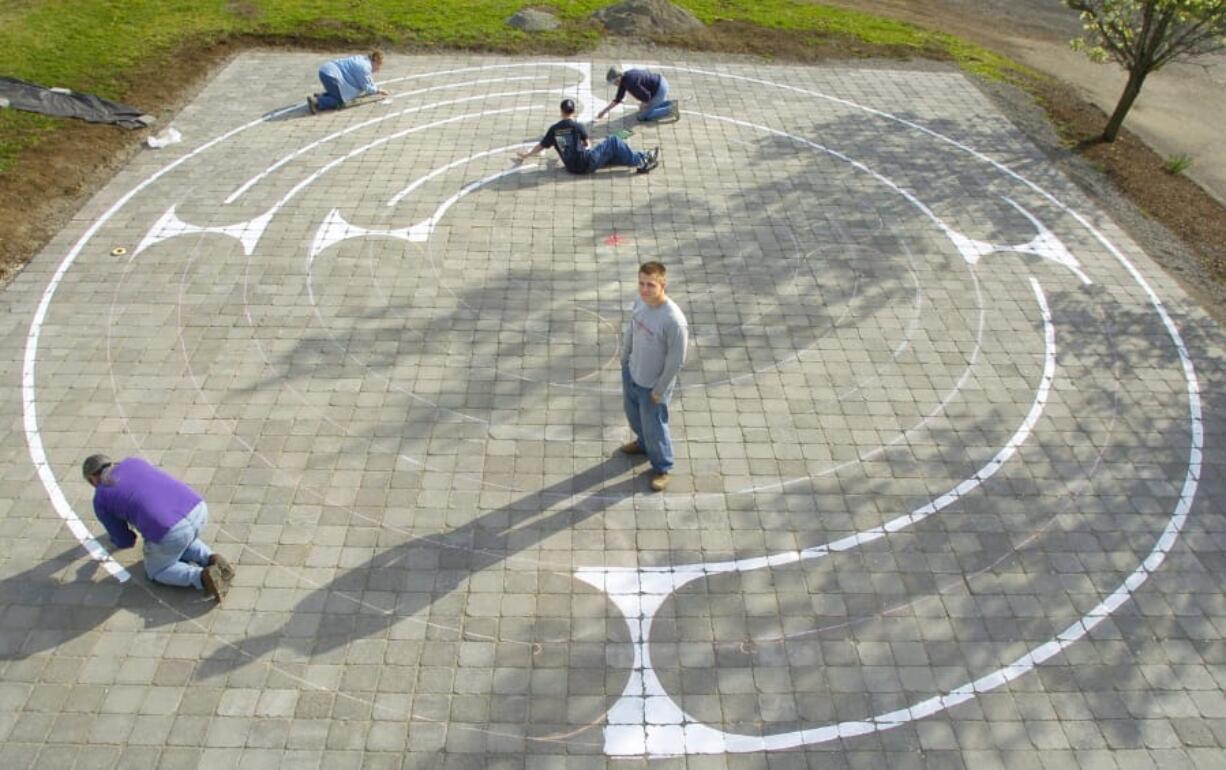 In this file photo from March 2005, Eagle Scout Peter Sterr, center, watches while friends and family paint a labyrinth pattern onto brick pavers at Beautiful Savior Lutheran Church in east Vancouver.