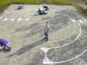 In this file photo from March 2005, Eagle Scout Peter Sterr, center, watches while friends and family paint a labyrinth pattern onto brick pavers at Beautiful Savior Lutheran Church in east Vancouver.