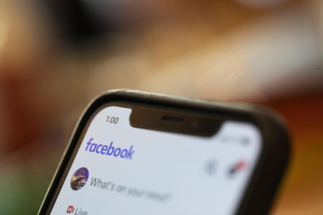 FILE - In this Aug. 11, 2019, file photo an iPhone displays a Facebook page in New Orleans. A Ukrainian security researcher says a database with the names, phone numbers and unique user IDs of more than 267 million Facebook users was exposed on the open internet for at least 10 days this month.