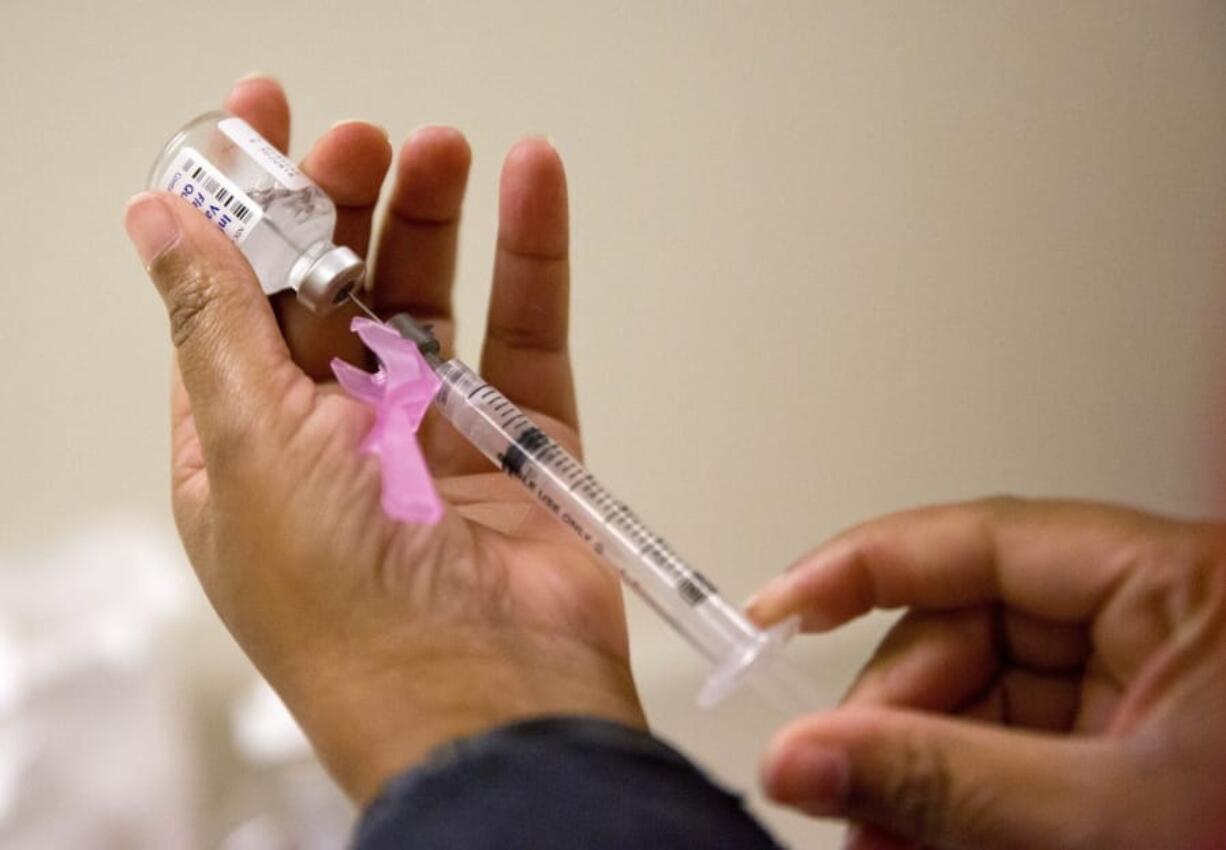 In this Feb. 7, 2018 file photo, a nurse prepares a flu shot at the Salvation Army in Atlanta.