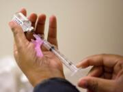 In this Feb. 7, 2018 file photo, a nurse prepares a flu shot at the Salvation Army in Atlanta.