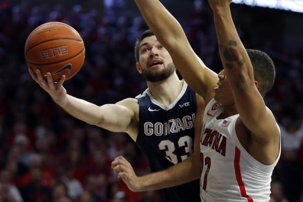 Gonzaga forward Killian Tillie (33) drives past Arizona forward Ira Lee in the first half of an NCAA college basketball game, Saturday, Dec. 14, 2019, in Tucson, Ariz.