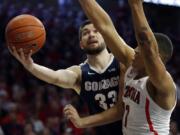 Gonzaga forward Killian Tillie (33) drives past Arizona forward Ira Lee in the first half of an NCAA college basketball game, Saturday, Dec. 14, 2019, in Tucson, Ariz.