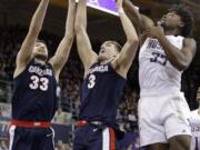 Gonzaga's Killian Tillie (33) and Filip Petrusev (3) reach for a rebound with Washington&#039;s Isaiah Stewart (33) in the first half of an NCAA college basketball game Sunday, Dec. 8, 2019, in Seattle.