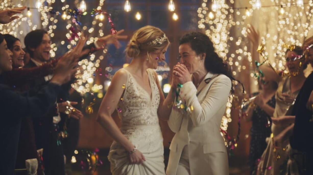 This image made from undated video provided by Zola shows a scene from its advertisement. The Hallmark Channel says it will reinstate same-sex marriage commercials that it had pulled from the network.