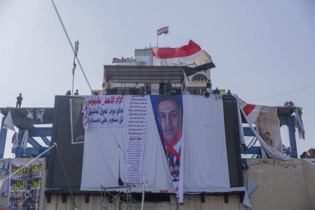 Protesters hang a big poster with a defaced picture of the governor of the southern Basra province Asaad al-Eidani and Arabic that reads &quot;rejected by the people,&quot; during the ongoing protests, in Tahrir Square, Baghdad, Iraq, Thursday, Dec. 26, 2019.