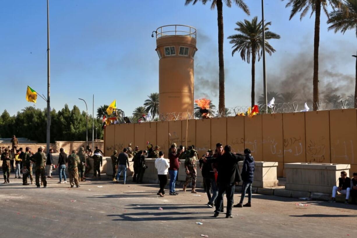 Protesters burn property in front of the U.S. embassy compound, in Baghdad, Iraq, Tuesday, Dec. 31, 2019. Dozens of angry Iraqi Shiite militia supporters broke into the U.S. Embassy compound in Baghdad on Tuesday after smashing a main door and setting fire to a reception area, prompting tear gas and sounds of gunfire.