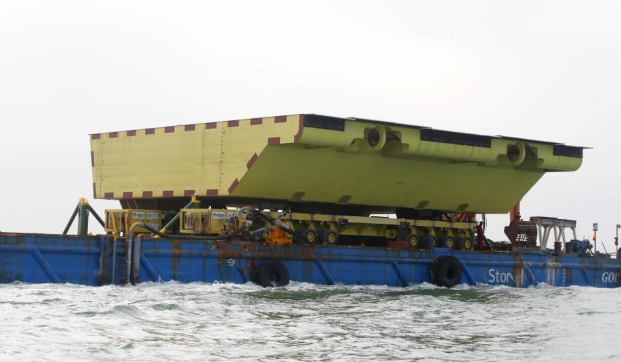 A yellow barrier, part of a plan to protect the city of Venice from flooding, floats on a barge, in Venice, Italy, Friday, Nov. 29, 2019. Central to the plan to protect Venice, some, or all, of the 78 barriers will one day be raised when the sea rises more than 110 centimeters to prevent damaging high tides from pushing into the lagoon city, a UNESCO heritage site built picturesquely but somewhat precariously among more than 120 islands.