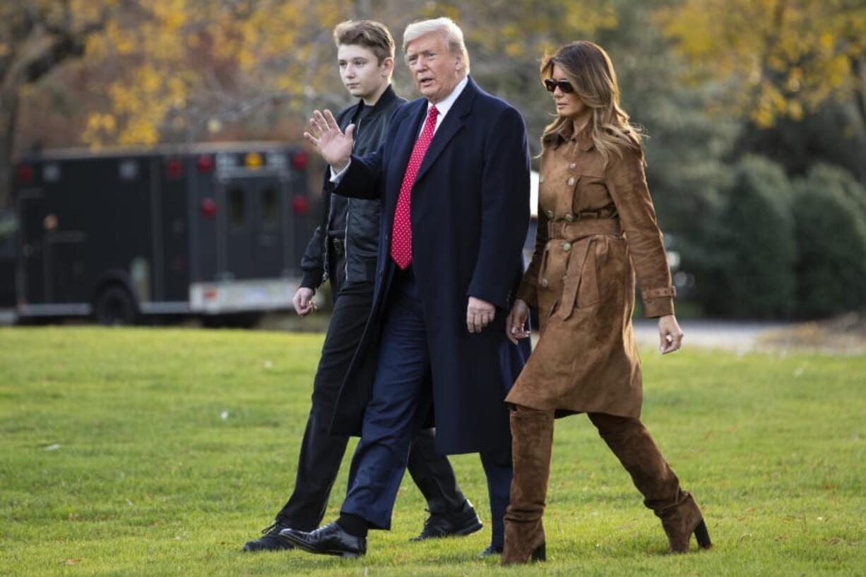 FILE- In this Nov. 26, 2019, file photo, President Donald, first lady Melania Trump, and Barron Trump, walk to board Marine One on the South Lawn of the White House, in Washington. Melania Trump is quietly forging her way through President Donald Trump&#039;s impeachment.