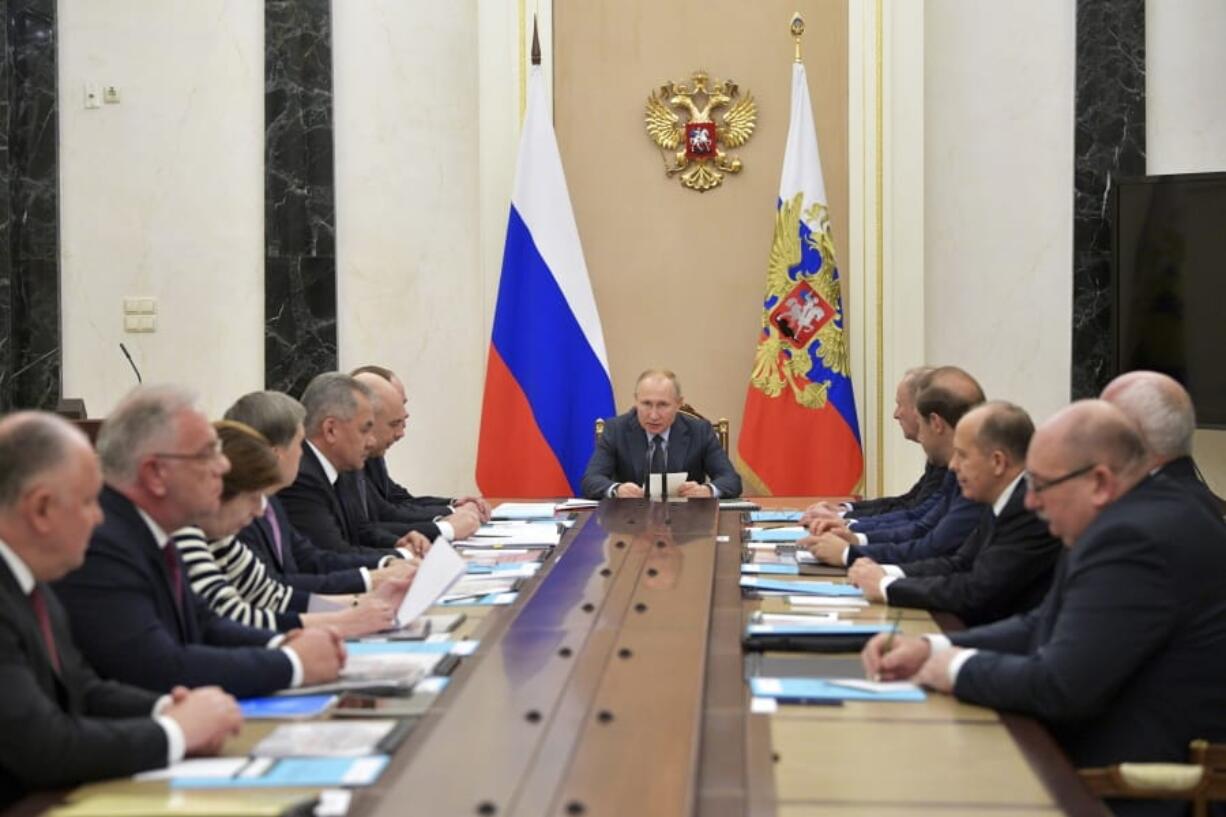 Russian President Vladimir Putin, center, attends a meeting on arms exports in Moscow, Russia, Monday, Dec. 16, 2019. Putin said Russian arms sales abroad has risen over the past year.