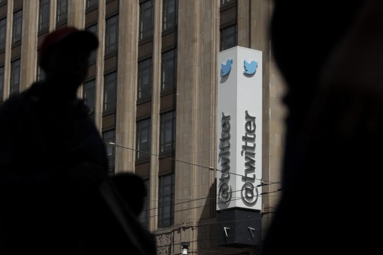 FILE - This July 9, 2019, file photo shows pedestrians walking across the street from the Twitter office building in San Francisco. Twitter says it has removed nearly 6,000 accounts it has deemed tied to a state-backed information operation in Saudi Arabia.