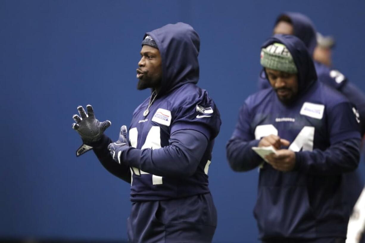 Seattle Seahawks running back Robert Turbin, left, stands near running back Marshawn Lynch, who looks over notes during warmups at the team&#039;s practice facility Tuesday.