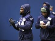 Seattle Seahawks running back Robert Turbin, left, stands near running back Marshawn Lynch, who looks over notes during warmups at the team&#039;s practice facility Tuesday.