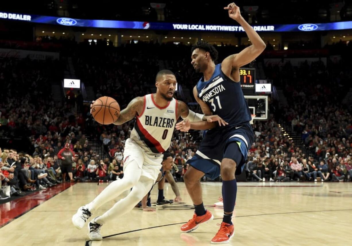 Portland Trail Blazers guard Damian Lillard, left, drives to the basket on Minnesota Timberwolves forward Keita Bates-Diop, right, during the second half of an NBA basketball game in Portland, Ore., Saturday, Dec. 21, 2019. The Blazers won 113-106.