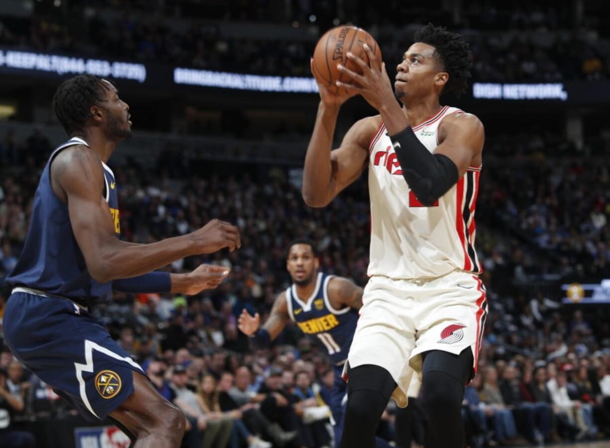 Portland Trail Blazers center Hassan Whiteside, right, shoots for a basket over Denver Nuggets forward Jerami Grant in the first half of an NBA basketball game Thursday, Dec. 12, 2019, in Denver.