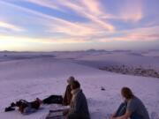 Campers catch the sunset on top of the dunes in White Sands National Park in New Mexico.