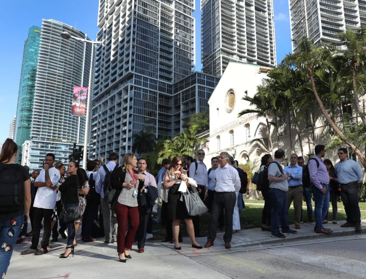 People wait outside after evacuating office buildings after an earthquake struck south of Cuba on January 28, 2020 in Miami, Fla.