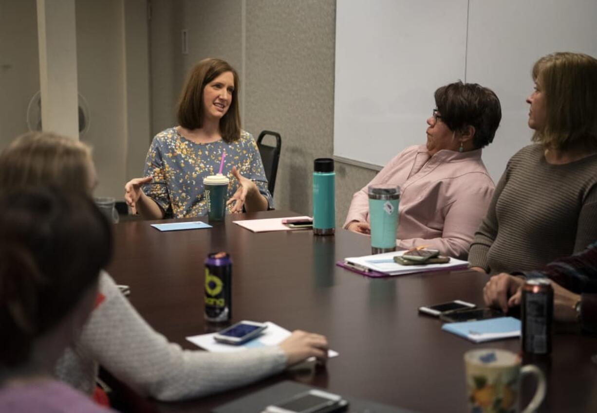 Clinical supervisor Brook Vejo, center, talks with the Youth Mobile Crisis Intervention team during its meeting at Catholic Community Services in Vancouver. The organization works with teenagers who are in a mental health crisis in an effort to keep them out of the emergency room.