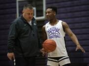 Heritage head coach Brian Childs listens as point guard Capone Johnson asks about a play during a practice Jan. 13 at Heritage High School.