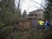 J.R. Ramsey, from left, and Guy Price of Advanced Earth Stabilization consult with homeowner Richard Schwartz of Ridgefield about the landslide in his backyard. Schwartz has been trying to get his yard fixed for more than two years after heavy rain and a neighboring stormwater pond caused a landslide on the hill behind his house.