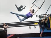 Brittany Ashworth, owner of Premier Cirque in Hazel Dell, swings during a Saturday trapeze class. She founded the business because she was tired of commuting to classes in Portland.