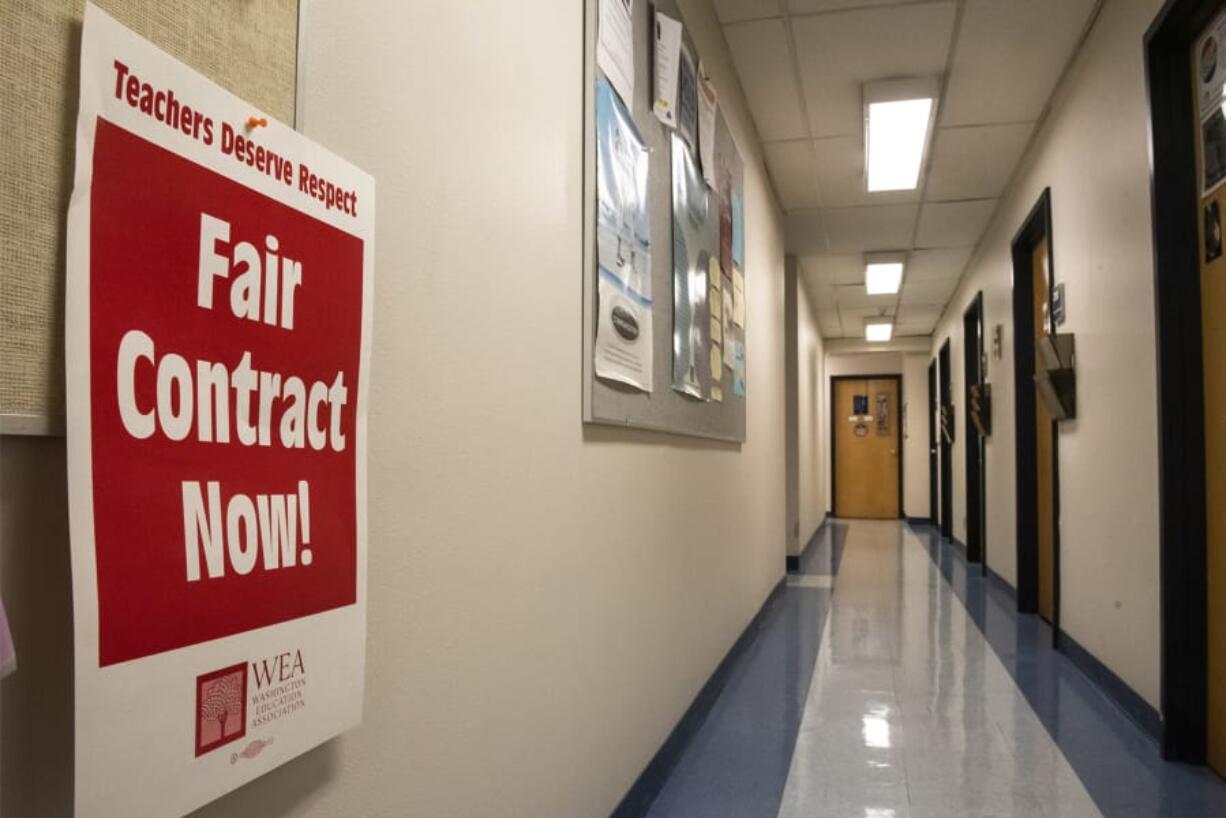 A poster signaling support for the Association for Higher Education hangs in a hallway of faculty offices in Foster Hall at Clark College on Monday afternoon. Faculty are poised to strike Jan. 13 if a deal is not reached between the union and college administration.
