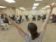 Laura Lou Pape-McCarthy leads a movement class to help patients with Parkinson&#039;s disease prevent falls, improve speech and facial expressions, and find a sense of community. Pape-McCarthy leads the class in upper body and vocal stretches. The class is offered through Parkinson&#039;s Resources of Oregon.