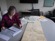 Norma Countryman looks over documents related to Warren Forrest's 1974 murder of Krista Blake at The Columbian on Jan. 10. On the table is a timeline used in the trial.