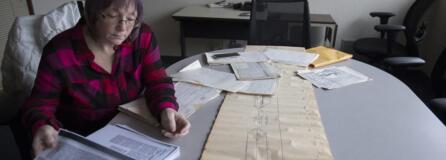 Norma Countryman looks over documents related to Warren Forrest's 1974 murder of Krista Blake at The Columbian on Jan. 10. On the table is a timeline used in the trial.