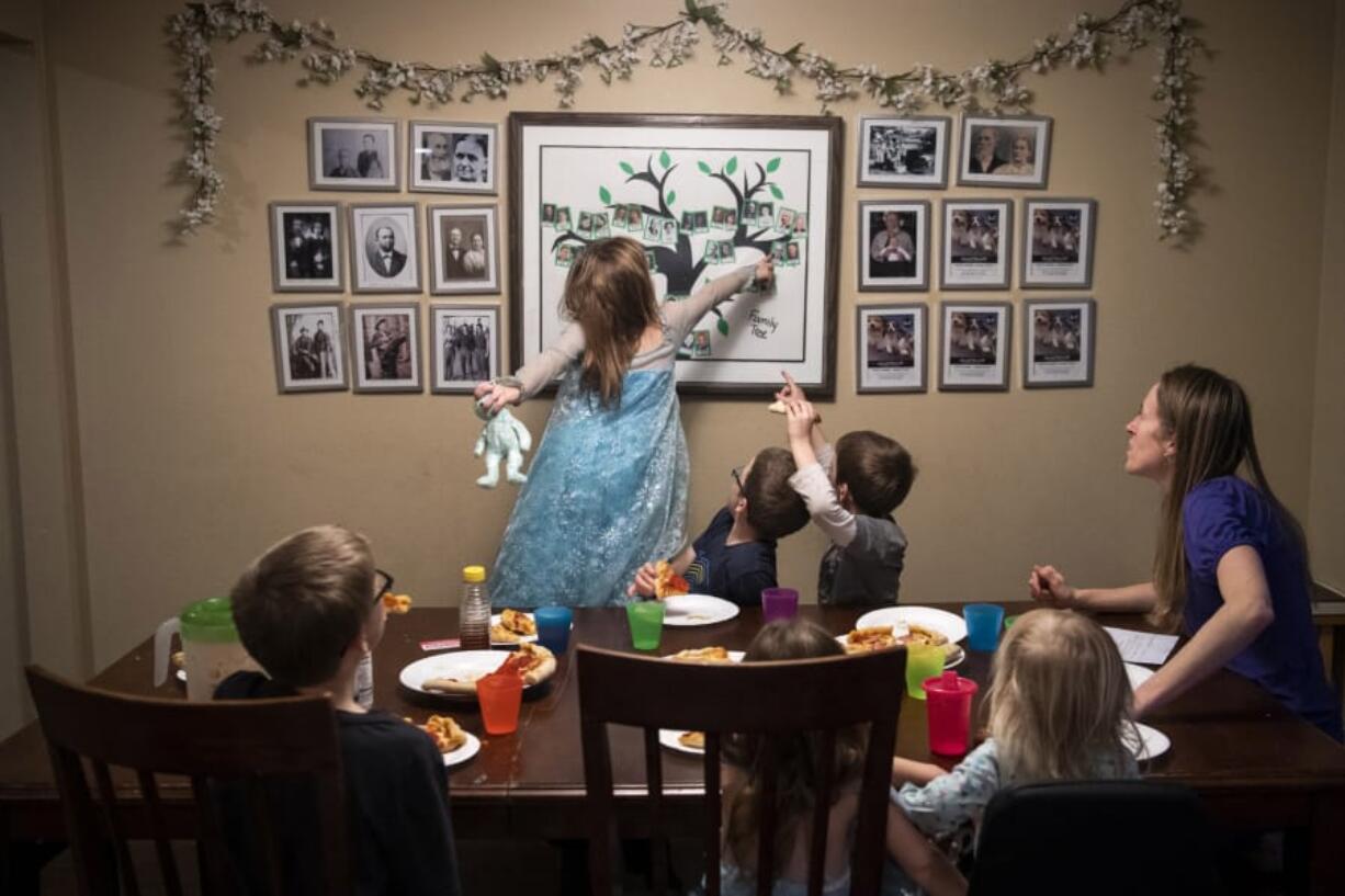 Hannah Barnes, 5, points to one of her great-grandparents as the family plays a family history trivia game during dinner Jan. 10 at the Barnes home in Vancouver. Charlotte Barnes said meals are often the only time they&#039;re all sitting together, so they like to tell family stories or play family history trivia games as they eat. Jonah and Charlotte Barnes&#039; book &quot;Turning Little Hearts,&quot; an activity book &quot;to connect children with their ancestors,&quot; was recently released. It's available online and at Sunrise Bagels, 808 Harney St.