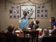 Hannah Barnes, 5, points to one of her great-grandparents as the family plays a family history trivia game during dinner Jan. 10 at the Barnes home in Vancouver. Charlotte Barnes said meals are often the only time they&#039;re all sitting together, so they like to tell family stories or play family history trivia games as they eat. Jonah and Charlotte Barnes&#039; book &quot;Turning Little Hearts,&quot; an activity book &quot;to connect children with their ancestors,&quot; was recently released. It's available online and at Sunrise Bagels, 808 Harney St.