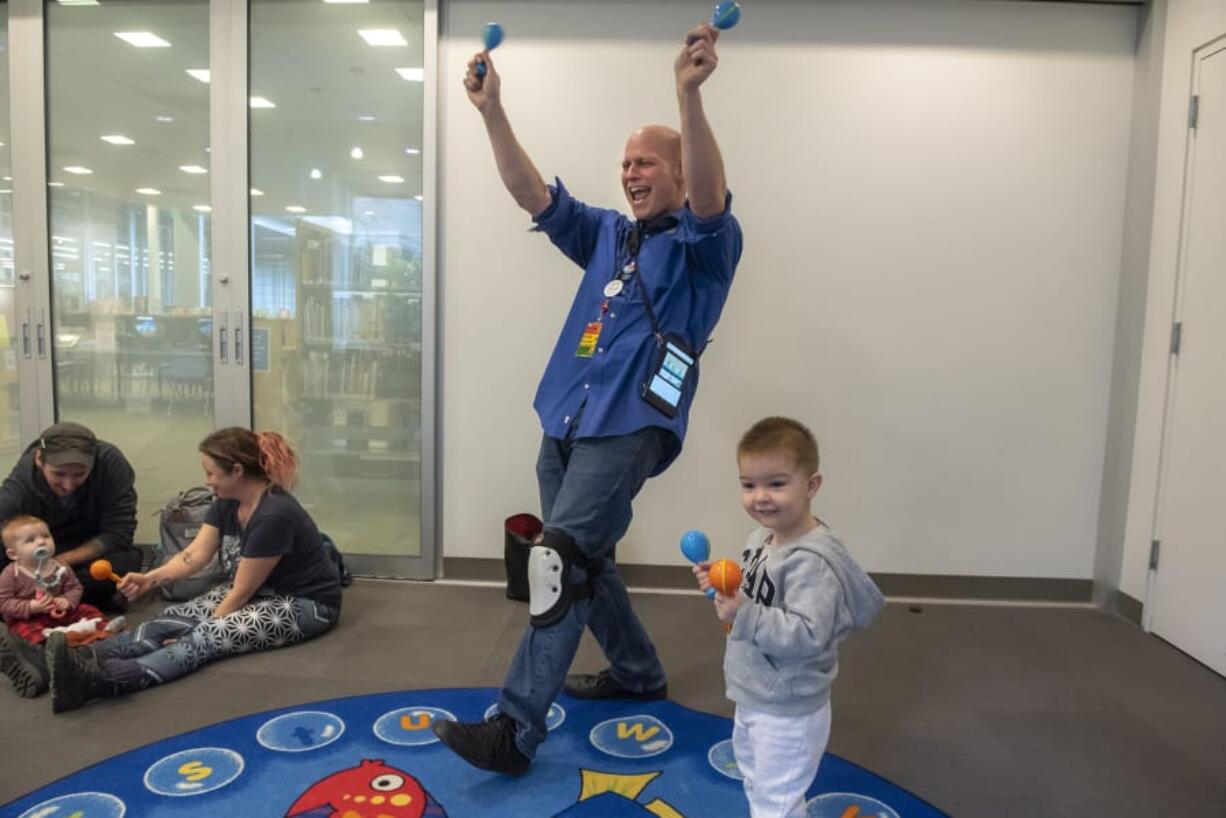 Senior Library Assistant Steve Williams, left, and Matteo Cojocaru, 2, lead the Baby Storytime group in song and dance at the Cascade Park Community Library on Thursday afternoon. The library soon will close for three weeks for minor remodeling.